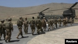 Солдаты НАТО садятся в вертолет после церемонии передачи контроля над безопасностью в стране. Кабул, 18 июня 2013 года.