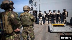 Membri ai forțelor speciale române și marinari americani într-un exercițiu militar la bordul distrugătorului american Truxtun în Marea Neagră.