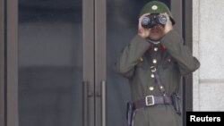 Севернокорејски војник ја набљудува границата со Јужна Кореја.