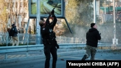 A Ukrainian policeman shoots at a suicide drone during a new Russian attack on Kyiv on October 17. 