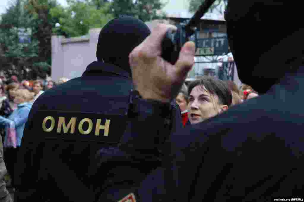 A woman protestor talks to police officers.