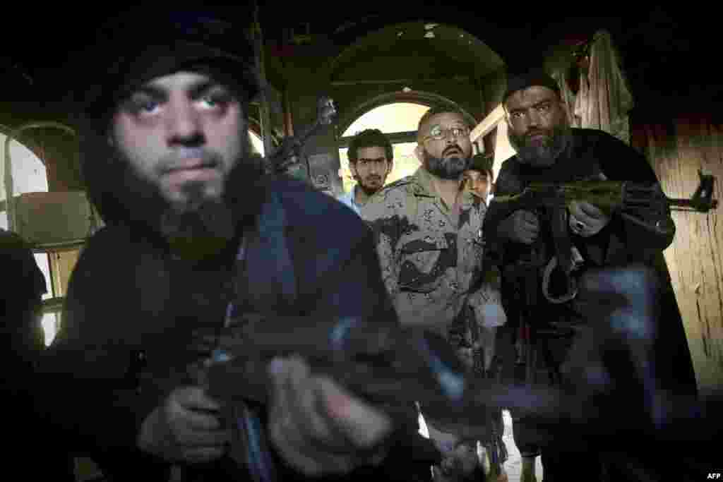 Сырыйскія паўстанцы займаюць пазыцыю ў доме падчас сутычак з урадавымі сіламі ў Алепа.