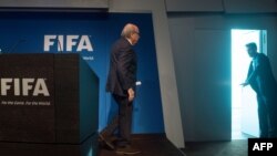 Прэзыдэнт ФІФА Ёзэф Блатэр пакідае праз "чорны ход" прэс-канфэрэнцыю ў Цюрыху, на якой ён абвясьціў пра сваю хуткую адстаўку, 2 чэрвеня 2015 году