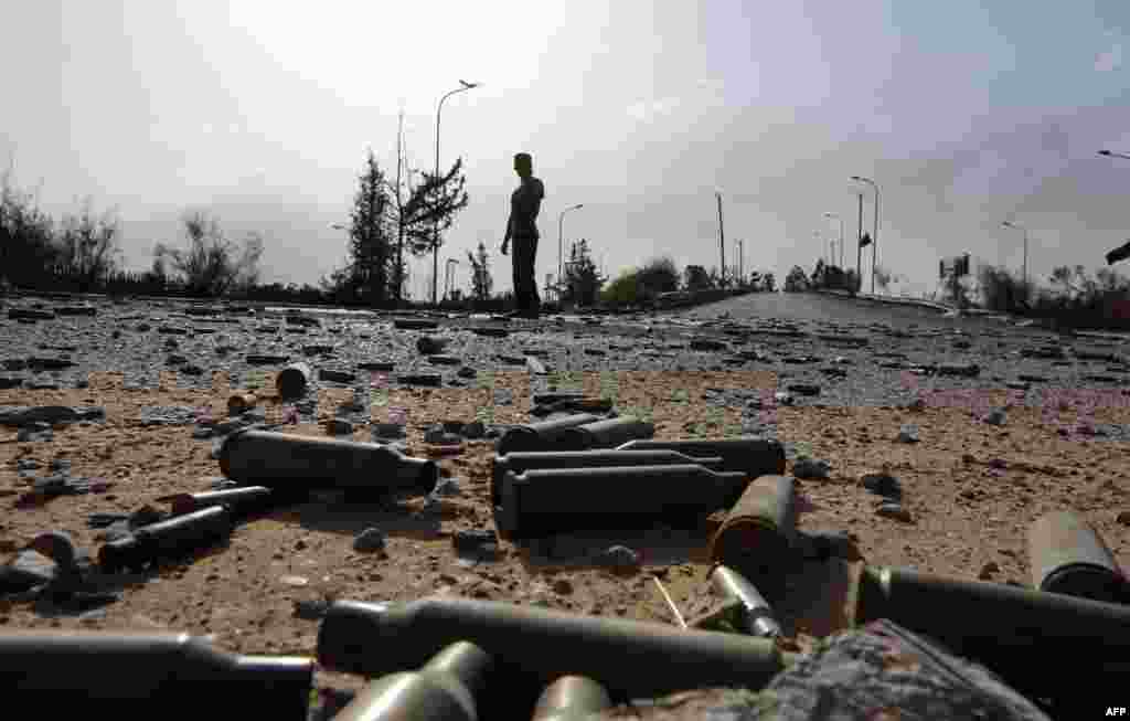 Spent bullet shells litter the ground as a member of the Islamist-linked militia of Misurata walks past following three days of battles in the area of Tripoli's international airport on August 21. (AFP/Mahmud Turkia)