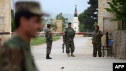 Afghan security personnel keep watch near the site of an attack on an army compound in Balkh Province on April 21.