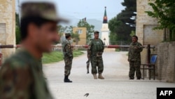 Afghan security personnel keep watch near the site of an attack on an army compound in Balkh Province on April 21. 