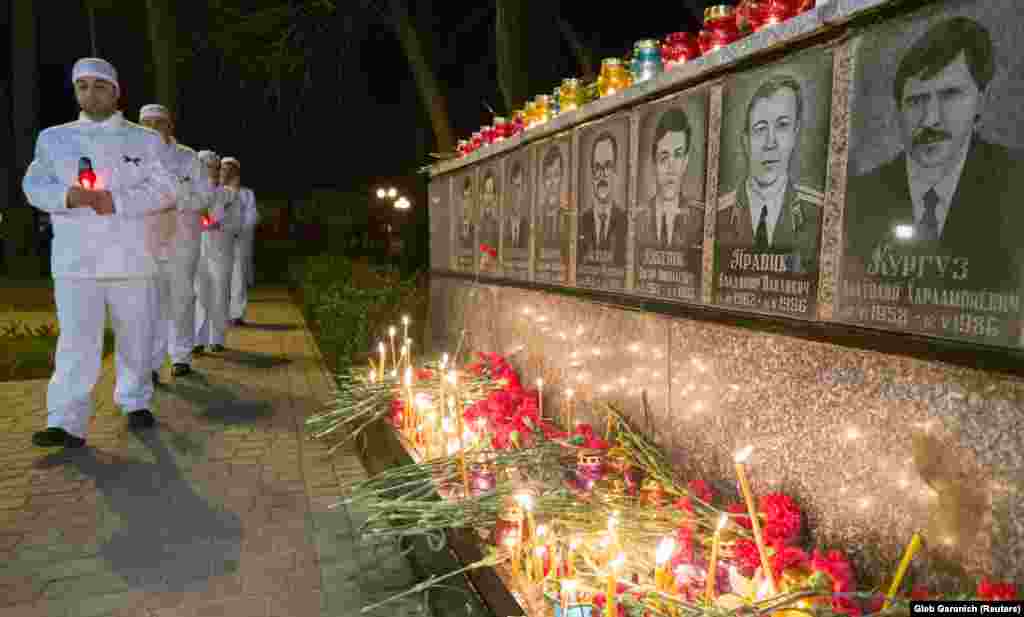 People carry candles in the Ukrainian city of Slavutych on April 26 at a memorial dedicated to firefighters and workers who died as a result of the 1986 Chornobyl nuclear disaster.