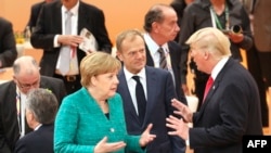 German Chancellor Angela Merkel (left to right), European Council President Donald Tusk, and U.S. President Donald Trump joke at the beginning of the third working session of the G20 meeting in Hamburg on July 8.