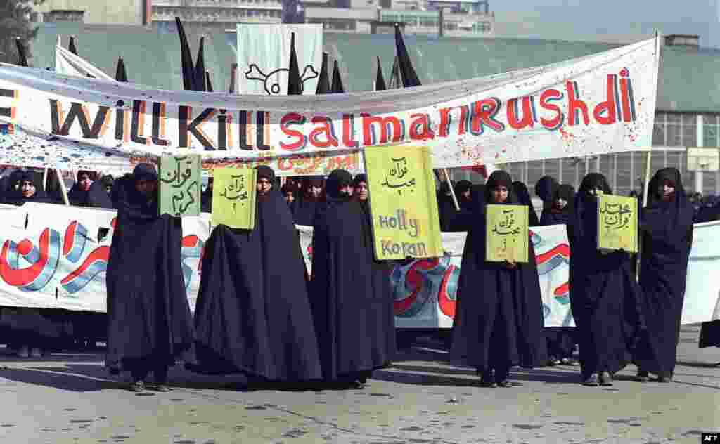 Women holding banners that read &quot;Holly Koran&quot; and &quot;We will kill Salman Rushdie&quot; during a demonstration in Tehran on February 17, 1989.