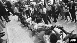 Fekete es fehér amerikaiak összeláncolva a New York-i varosháza előtt térdepelnek 1963. augusztus 23-án, hogy így tiltakozzanak a szegregáció ellen az Egyesült Államok bizonyos államaiban.