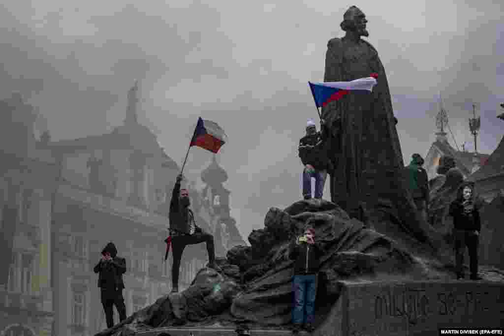 Demonstrators protesting the Czech government's restrictions wave flags during a rally at the Old Town Square in Prague, Czech Republic, October 18, 2020. 