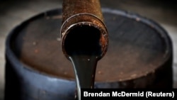 U.S. -- Oil pours out of a spout from Edwin Drake's original 1859 well that launched the modern petroleum industry at the Drake Well Museum and Park in Titusville, Pennsylvania, October 5, 2017