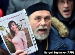 Un preot ortodox cu cu fotografia Irinei Nozdrovska la manifestații.