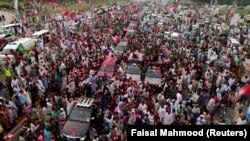 Supporters of former Pakistani Prime Minister Nawaz Sharif crowd around his car as his convoy enters Rawalpindi on August 9.