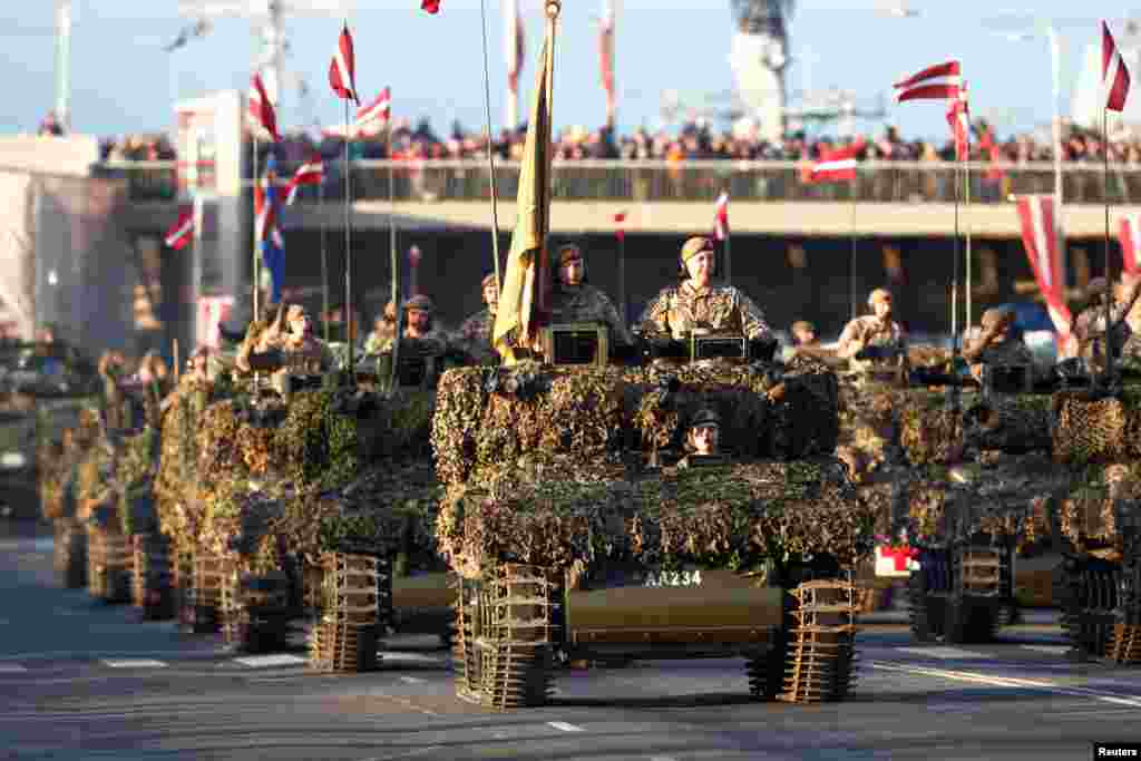 Солдати латвійської армії на бойових машинах розвідки їдуть вулицями Риги