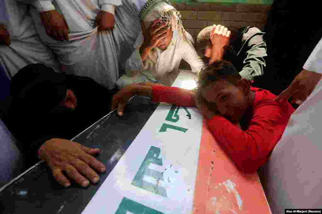 Mourners grieve on the coffin of a victim who was killed in a car-bomb attack in the Sadr City district of Baghdad. (Reuters/Alaa al-Marjani)