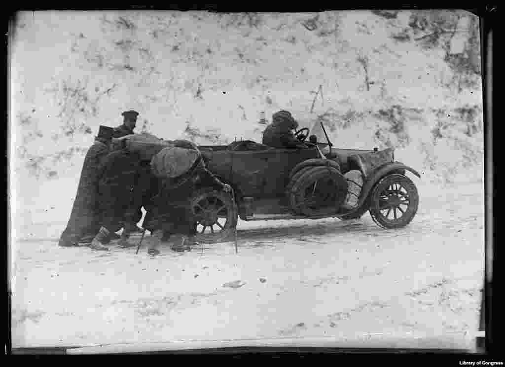 На этом снимке показаны испытания автомобиля Американского Красного Креста, который совершил поездку из Бухареста, Румынии, через Болгарию в сербский Пирот в ноябре 1919 года до реконструкции железной дороги. Было так холодно, что двигатель не работал должным образом. На фото крестьяне толкают автомобиль в гору
