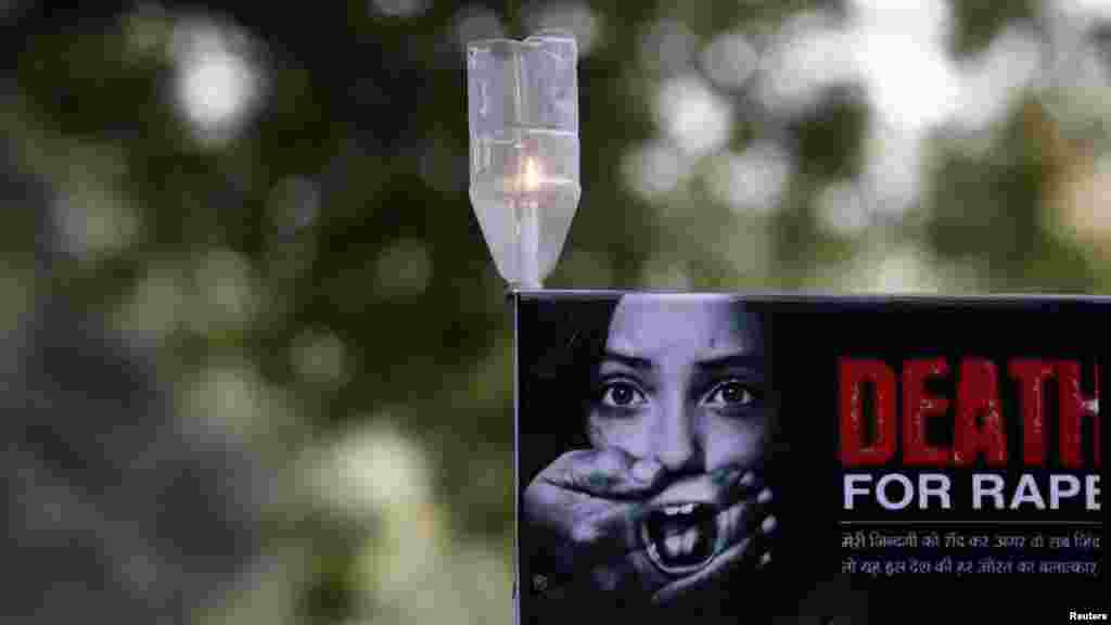 A candle is seen on a placard during a protest in New Delhi over the death of a woman who was gang-raped on a bus. (Reuters/Adnan Abidi)