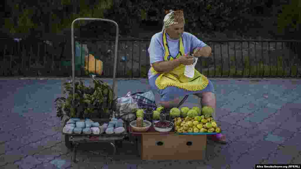 Женщина торгует фруктами неподалеку от пляжа