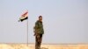 Сирийский военный на фоне флага