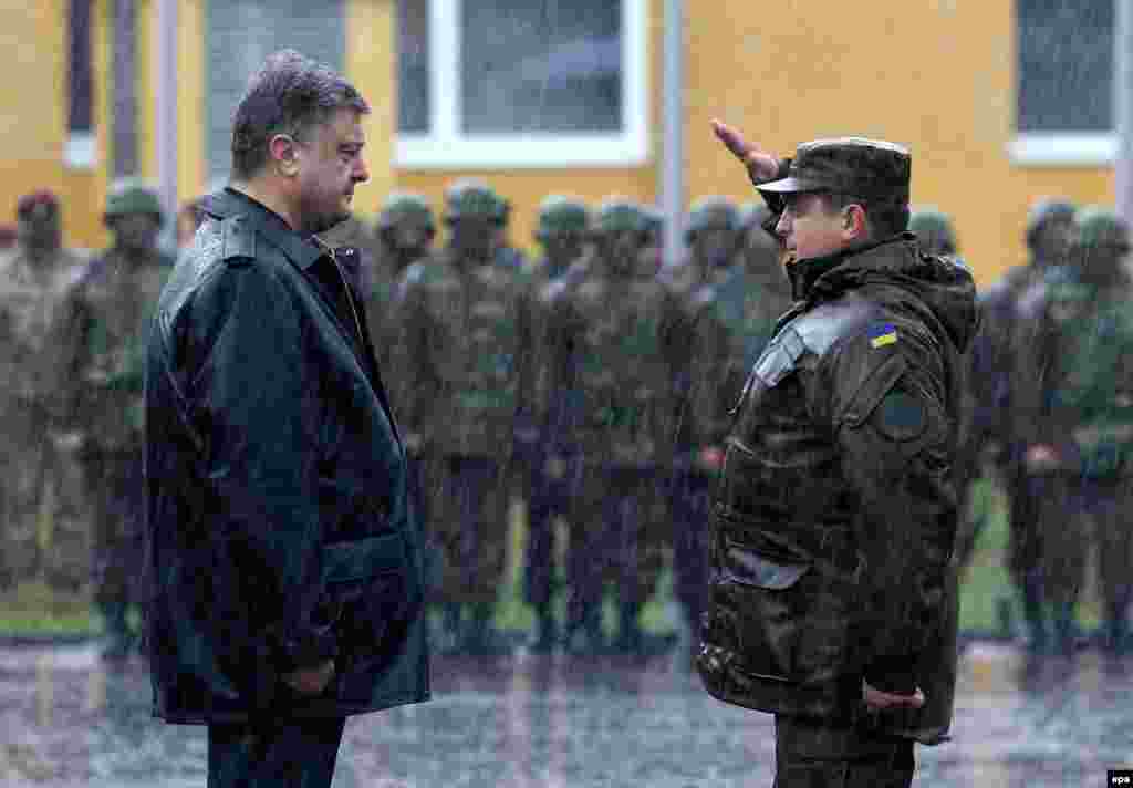 A Ukrainian soldier salutes President Petro Poroshenko (left) during the opening ceremony of joint military training exercises with the U.S. Army near the western city of Lviv. (epa/Sergei Dolzheko)