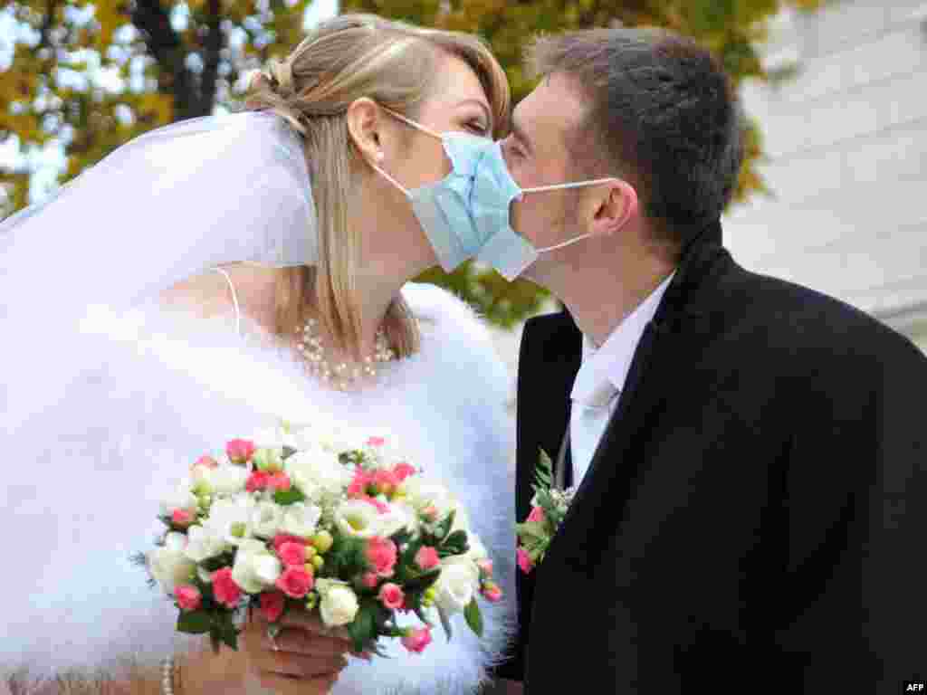 A newlywed couple kisses as they leave the city hall in Lviv.