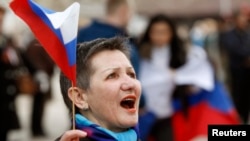 A pro-Russian demonstrator takes part in a rally in Simferopol on March 6 outside parliament as local legislators voted to join with Russia.