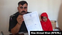 A police officer and a 6-year-old bride in Swat, in northwestern Pakistan, in a photo from a separate case from late October.