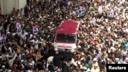 Supporters of Mumtaz Qadri shower rose pastels on an ambulance carrying his body for funeral in Rawalpindi, on March 1