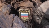 A dead soldier in Luhansk, Ukraine, bears the sigil of the Russian military on his uniform. 