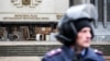 Сотрудник МВД стоит возле захваченного российскими военными здания крымского парламента. Симферополь, 27 февраля 2014 года