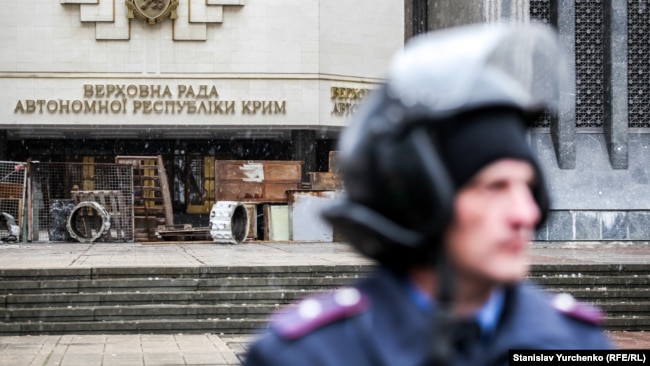 Сотрудник МВД Украины возле захваченного российскими военными здания Верховного Совета Крыма. Февраль 2014 года