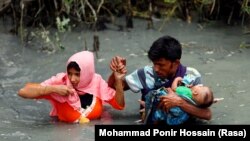 یک خانواده روهینگیایی حین فرار از رودی مرزی به بنگلادش