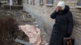 O femeie plânge alături de cadavrul fiului său, omorât în timpul bombardamentului spitalului din Textilșcik, Donețk, 4 februarie