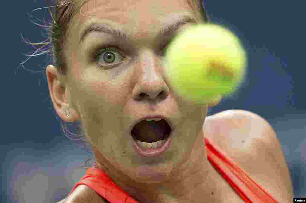 Simona Halep of Romania watches the ball as she returns a shot to Victoria Azarenka of Belarus during their quarterfinals match at the U.S. Open Championships tennis tournament in New York. Halep won 6-3, 4-6, 6-4. (Reuters/Carlo Allegri)