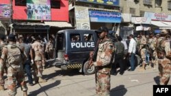 Pakistan -- Pakistani security personnel gather around a police van after an attack by gunmen on security members guarding a polio vaccination team in Karachi, April 20, 2016