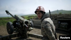 Nagorno-Karabakh -- An Armenian soldier stands next to a cannon at the artillery positions near Nagorno-Karabakh's town of Martuni, April 8, 2016