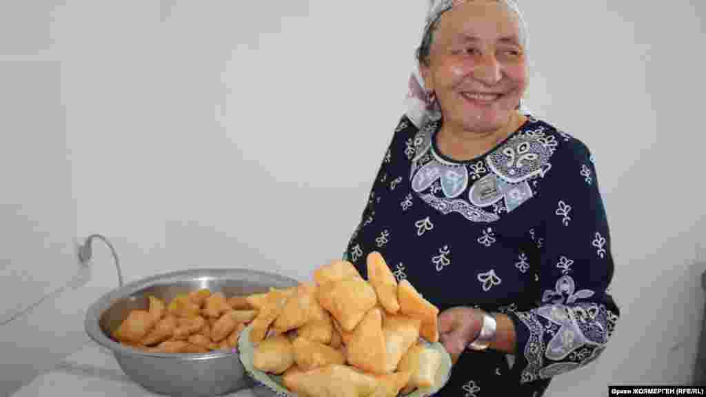Его жена несет национальное угощение — бауырсак.
