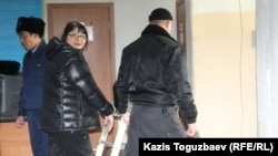 Редактора оппозиционного сайта Nakanune.kz Гузяль Байдалинову (в центре) ведут в зал заседания суда в наручниках. Алматы, 26 декабря 2015 года. 