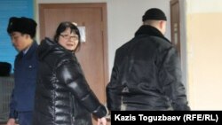 Редактора оппозиционного сайта Nakanune.kz Гузяль Байдалинову (в центре) ведут в зал заседания суда в наручниках. Алматы, 26 декабря 2015 года.