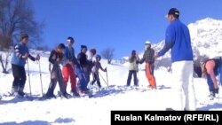 Арстанбаптык балдарга америкалык туристтер лыжа тебүүнү үйрөтүүдө