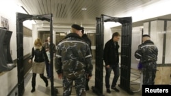 Police officers check passengers at the entrance to the Kamennaya Gorka metro station in Minsk today