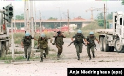 Українські та французькі миротворці ООН ховаються від снайперського вогню в центрі боснійської столиці Сараєво під час осади та обстрілів міста військами боснійських сербів. 21 липня 1994 року