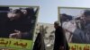 Iraqis walk past posters of Prime Minister Nuri al-Maliki in the Bab al-Sharqi district of Baghdad this month.