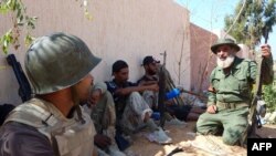 Fighters from Libya's National Transitional Council (NTC) take cover on the front line in the key Red Valley on the road to Muammar Qaddafi's hometown of Sirte on September 9.