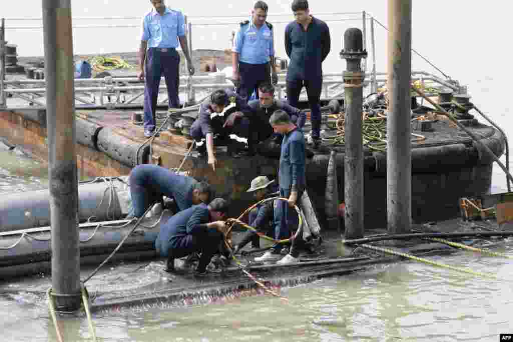 14 августа в порту Мумбаи взорвалась и затонула подводная лодка вооруженных сил Индии "Синдхуракшах", произведенная в России. По официальным данным, в результате ЧП пропали без вести 18 моряков. Подводная лодка, произведенная 16 лет назад, незадолго до трагедии прошла комплексный ремонт в России. На фото: спасательные работы на месте аварии подводной лодки "Синдхуракшах".