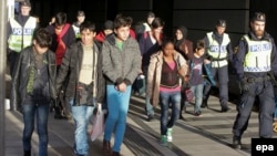 A group of migrants off an incoming train gather on the platform at the Swedish end of the bridge between Sweden and Denmark.