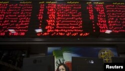 An official works at her desk in the main hall of the Tehran Stock Exchange in early August.