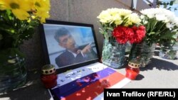 Мәскеу көпірі маңындағы Борис Немцов қаза тапқан жердегі оның суреті мен гүлдер.