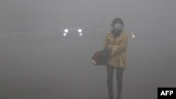 Қытайдың солтүстік-шығысындағы Хэйлунцзян провинциясында түтіннен сақтанып, маска киіп алған әйел (Көрнекі сурет).